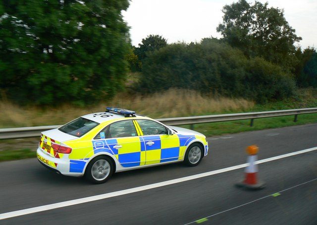 A marked police car on a road in the West Midlands