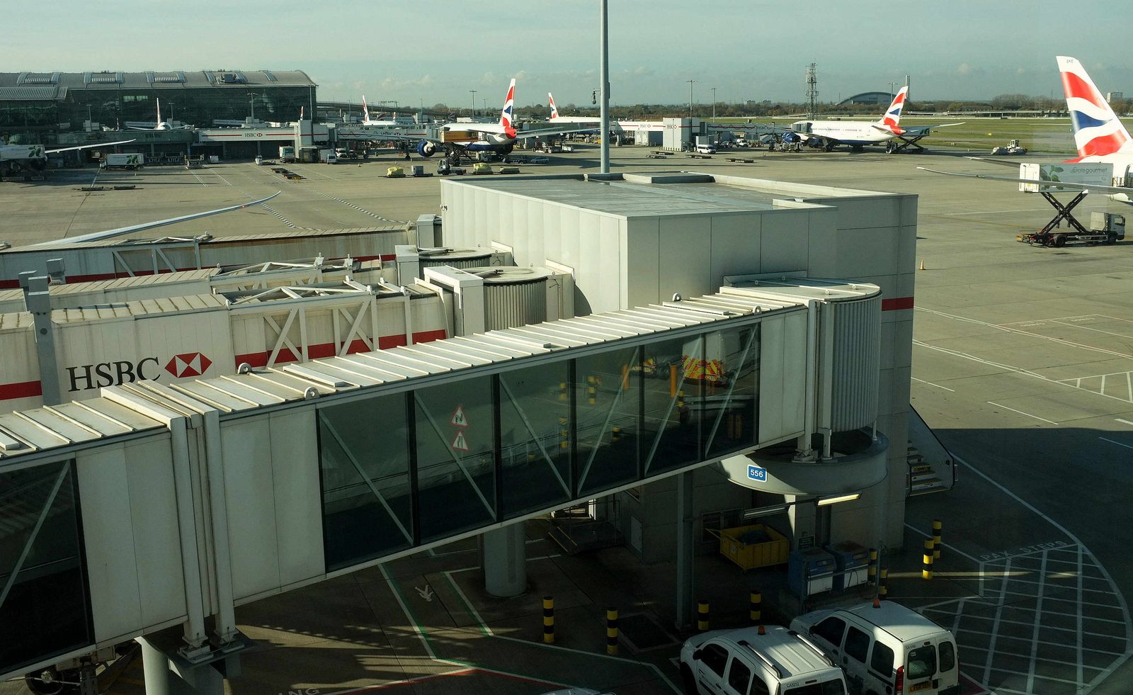 A jet bridge at a gate at Heathrow Airport, with British Airways aircraft parked on the apron behind it