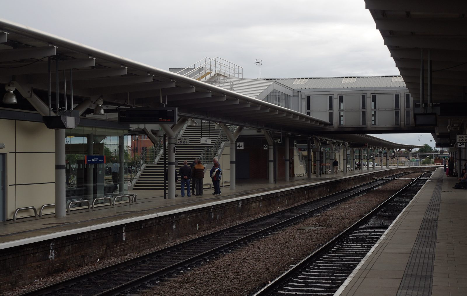 Passengers on the platforms at Derby railway station, with tracks in the foreground