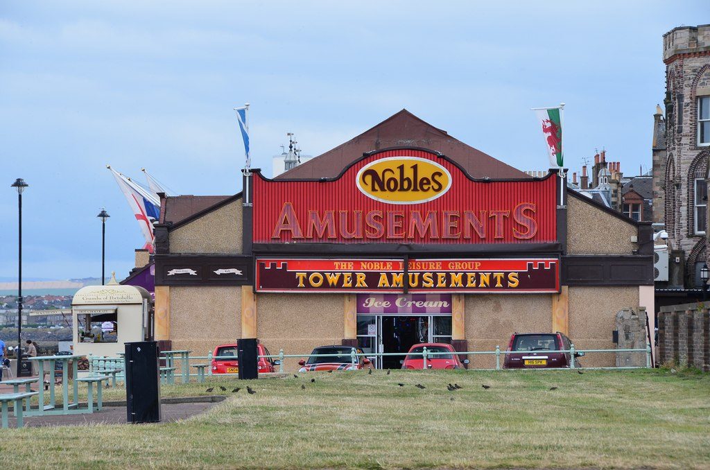 The Nobles Tower Amusements arcade, with its red signage, seen across a grassed area