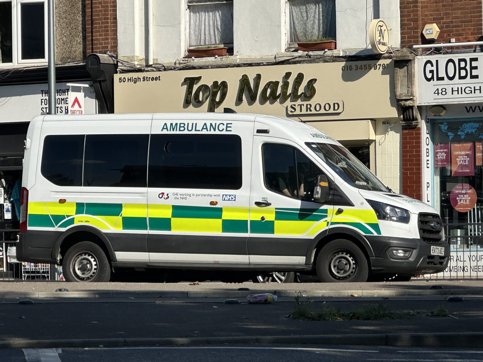 An NHS patient transport ambulance on the high street in Strood, Kent