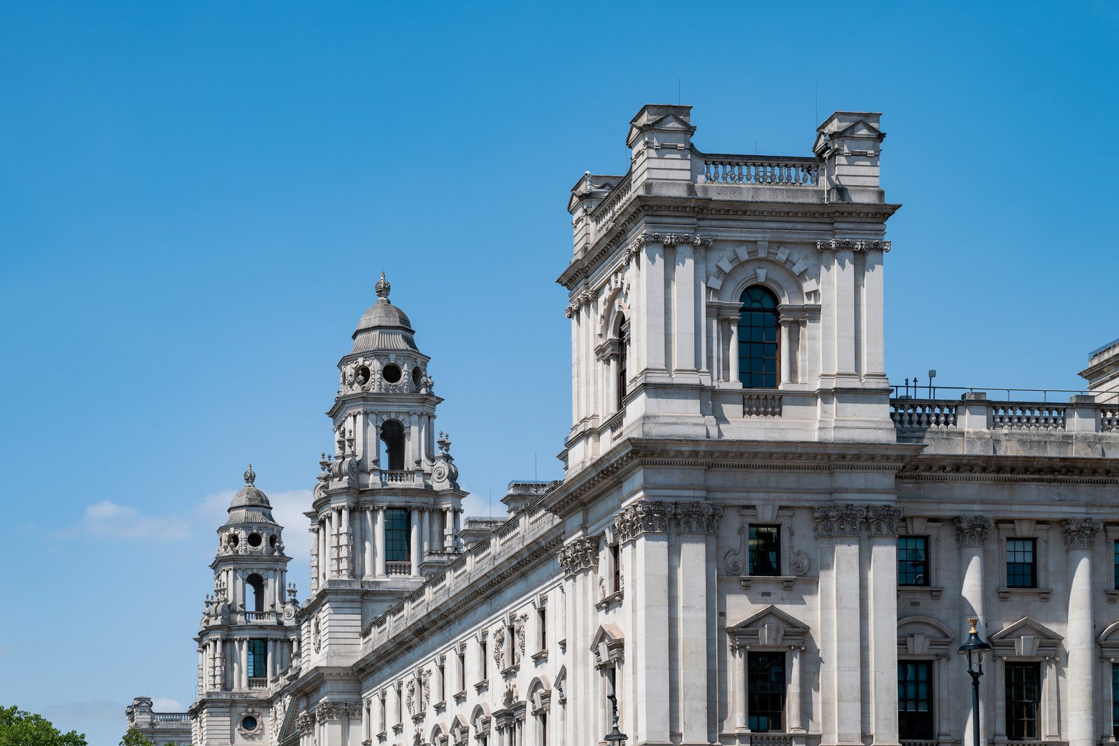 The HM Treasury building on Whitehall in London, photographed against a clear blue sky