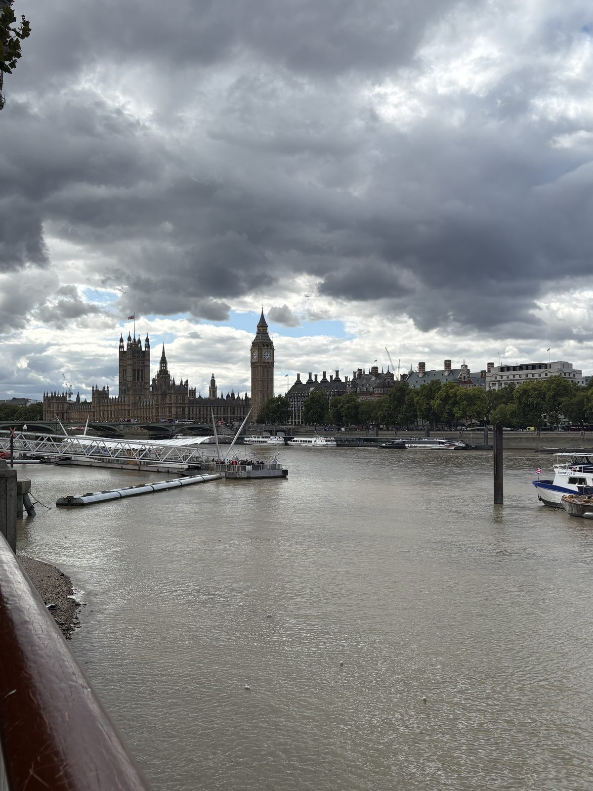 The Palace of Westminster across the Thames under dramatic clouds